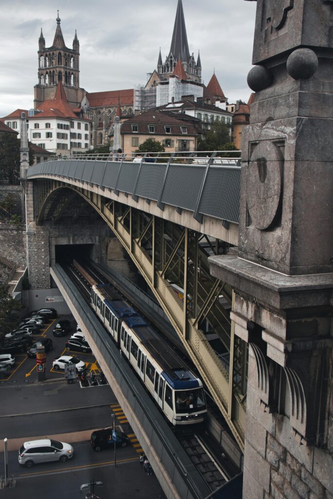 A scenic view of Lausanne's metro system passing below the historic Cathedral Saint Pierre.